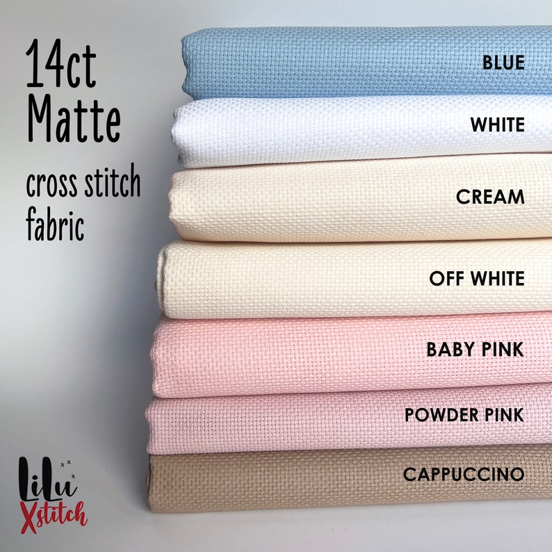 May include: A stack of 14 count Aida cloth fabric in various colors, including blue, white, cream, off-white, baby pink, powder pink, and cappuccino. The fabric is labeled "14ct Matte cross stitch fabric".