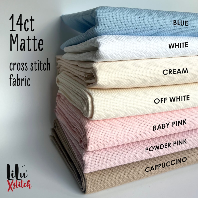May include: A stack of 14 count Aida cloth in various colors, including blue, white, cream, off white, baby pink, powder pink, and cappuccino. The fabric is labeled "14ct Matte cross stitch fabric".