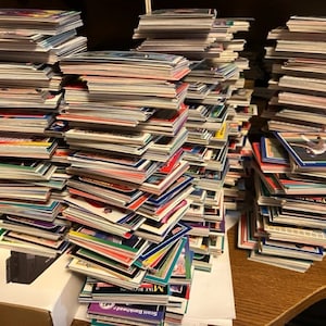 May include: A large stack of baseball trading cards, mostly in white, blue, and red, with some featuring player names like "Scott Brosius" and "Mike Piazza".