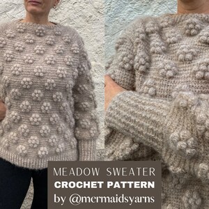 Puede incluir: Un suéter de crochet beige con un patrón de punto de relieve texturizado. El suéter tiene un cuello redondo y mangas largas. El texto "MEADOW SWEATER CROCHET PATTERN by @mermaidsyarns" está en la parte inferior de la imagen.