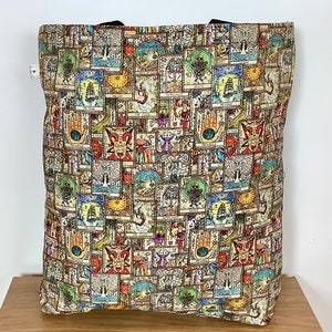 Op de afbeelding: Een tote bag met een kleurrijk ontwerp met een herhalend patroon van tarotkaarten. De kaarten zijn in verschillende kleuren en stijlen en zijn willekeurig gerangschikt. De tas is gemaakt van een duurzame stof en heeft twee handvatten.