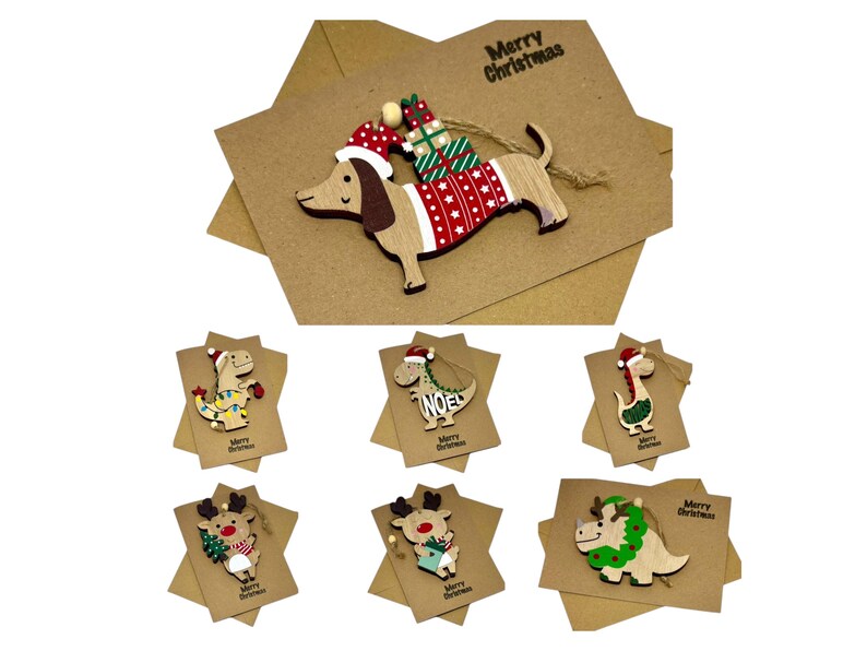 Op de afbeelding: Houten kerstversieringen met een teckel met een kerstmuts en trui, en diverse dinosaurussen en rendieren. Elk ornament zit op een stervormige kaart met de tekst "Merry Christmas" erop.