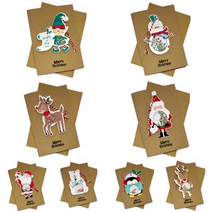 Op de afbeelding: Een verzameling kerstkaarten met verschillende feestelijke ontwerpen. Elke kaart toont een ander personage, waaronder een elf, een sneeuwman, een rendier en de kerstman, met de tekst "Merry Christmas" erop.