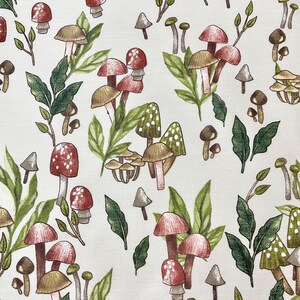 May include: A white fabric with a repeating pattern of red and brown mushrooms with green leaves. The mushrooms are of various sizes and shapes.