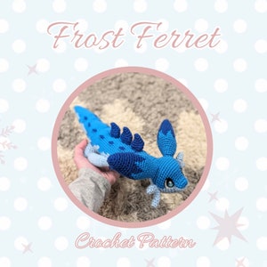 Puede incluir: Patrón de crochet para un amigurumi de hurón helado azul y blanco. El hurón está acostado sobre una alfombra marrón con la cabeza girada hacia un lado. El patrón está disponible para su compra.