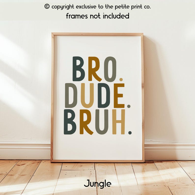 May include: A framed art print with the words "BRO. DUDE. BRUH." in dark green, gold, and tan colors. The word "Jungle" is at the bottom. The frame is a light brown color. The text "copyright exclusive to the petite print co. frames not included" is at the top.