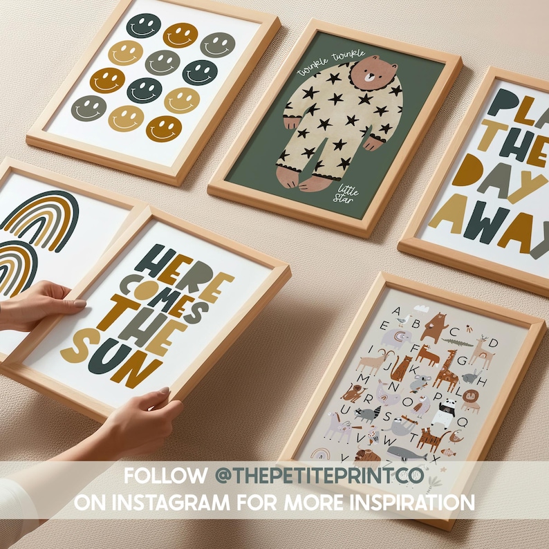 May include: A collection of framed art prints with various designs. One print features smiley faces, another a bear in star pajamas, and a third with the text "HERE COMES THE SUN." Other prints include an alphabet and a rainbow. The frames are light wood.