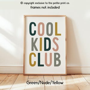 May include: A rectangular wall art print featuring the text COOL KIDS CLUB in a bold, sans-serif font. The letters are colored in alternating shades of dark green, muted pink, sage gray, and mustard yellow against a plain white background.