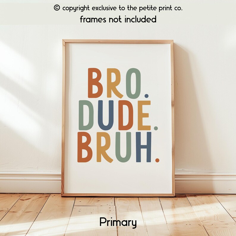 May include: A framed print with the words "BRO. DUDE. BRUH." in orange, blue, green, and rust-colored letters. The print is in a wooden frame and is displayed on a wall. The text "copyright exclusive to the petite print co. frames not included" is at the top.