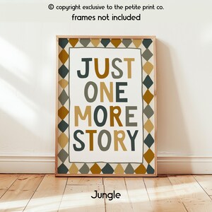 May include: A rectangular wall art print featuring the text "JUST ONE MORE STORY" in a mix of dark grey and mustard yellow letters. The central text is enclosed by a border of repeating diamond shapes in shades of dark grey, mustard, and tan.