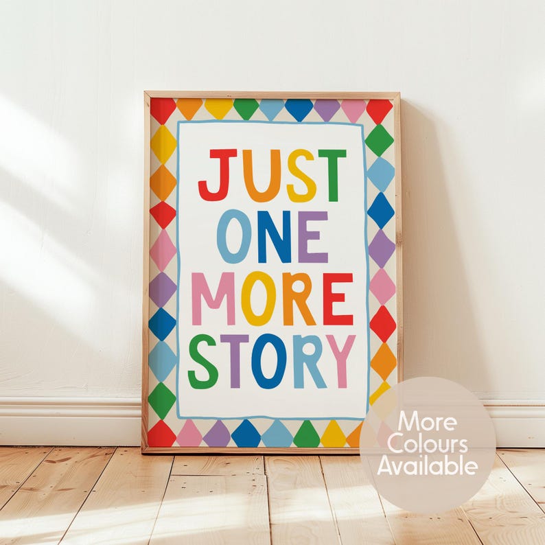 May include: A rectangular framed wall art print featuring the text JUST ONE MORE STORY in multicoloured capital letters. The border consists of a repeating pattern of colourful diamonds in red, orange, yellow, green, blue, and purple hues.