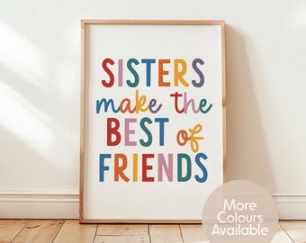 May include: A framed wall art print featuring the text "SISTERS make the BEST of FRIENDS" in a multi-coloured, rounded sans-serif font. The letters are displayed in shades of red, blue, yellow, purple, and green on a white background.