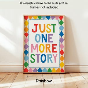 May include: A rectangular wall art print featuring the text JUST ONE MORE STORY in multicoloured letters. The print is surrounded by a border of colourful diamond shapes in red, orange, yellow, green, blue, and purple. The background is white.