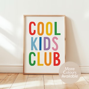 May include: A rectangular wall art print in a light wood frame featuring the text COOL KIDS CLUB in bold, multi-colored sans-serif letters. The words are stacked in three rows with red, orange, yellow, green, blue, purple, and pink colors.