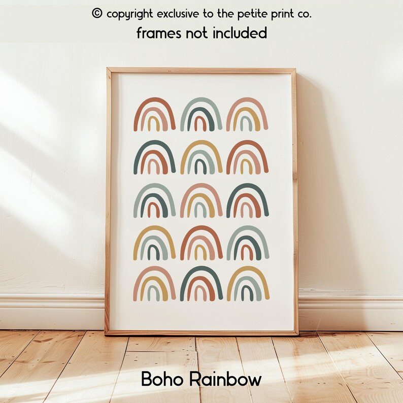 Op de afbeelding: Een ingelijste print met een herhalend patroon van regenboogbogen in bruine, groene en gele tinten. De tekst "Boho Rainbow" staat onderaan. De tekst "copyright exclusive to the petite print co. frames not included" staat bovenaan.