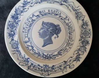 May include: White plate with blue floral and ribbon design. The plate features a portrait of a woman and the text "JUBILEE YEAR" and "DEI GRATIA". The plate is decorated with roses and other floral elements.