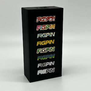 May include: A black display case with eight colorful enamel pins featuring the word "FIGPIN" in different patterns and colors.