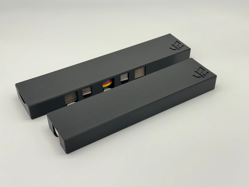 May include: Two black rectangular boxes with the word "VZ" printed on the top. The top box is open and has a deck of cards inside.