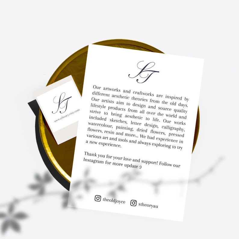 Pu&ograve; includere: Una carta bianca e un biglietto da visita con il logo "ST" in corsivo nero sono su un vassoio color oro. La carta pi&ugrave; grande ha un testo sull'arte e il design. Il biglietto da visita ha l'indirizzo del sito web.