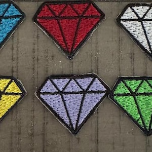May include: Six embroidered iron-on patches shaped like diamonds in different colors: blue, red, white, yellow, purple, and green.
