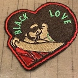 Peut inclure: Patch brodé en forme de cœur avec une silhouette noire d'un couple qui s'embrasse à l'intérieur. Les mots "BLACK LOVE" sont brodés en vert sur le cœur.