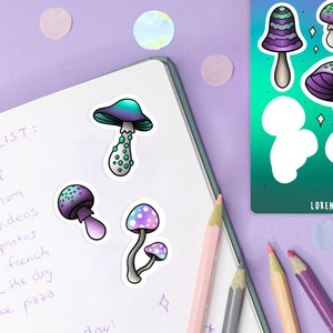 May include: A notebook with a to-do list written on it. There are four mushroom stickers on the notebook. The stickers are in various colors, including purple, blue, green, and white. The notebook is on a purple surface with a few colorful confetti pieces.