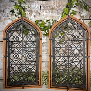 May include: Two wooden arched panels with a black geometric design. The panels are stained a light brown color and have a distressed look.