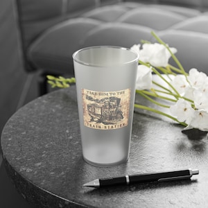 Op de afbeelding: Een bevroren glazen bierpul met een vintage-stijl afbeelding van een locomotief en de tekst "Take Him to the Train Station".
