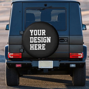 May include: Black SUV with a spare tire cover that says "YOUR DESIGN HERE" in white text.