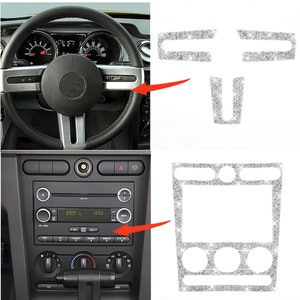 May include: Silver glitter car interior trim kit for a Ford Mustang. The kit includes trim pieces for the steering wheel, radio, and center console.