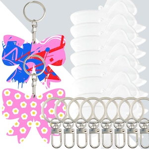 May include: Keyrings with bow-shaped pendants. One keyring features a pink bow with blue and red paint splatters. Another keyring has a pink bow with white and yellow flower designs. The keyrings have silver key rings and clasps.