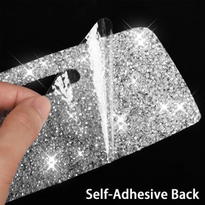 May include: A close-up of a silver sparkly adhesive sheet with a clear backing being peeled off. The sheet is covered in small, shiny rhinestones. The text "Self-Adhesive Back" is visible at the bottom of the image.