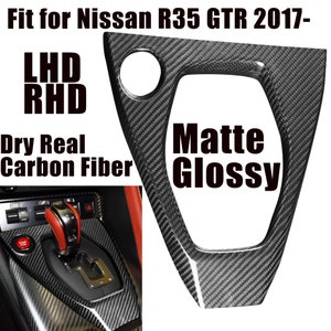 May include: Carbon fiber gear shift panel for a Nissan R35 GTR 2017. The panel is available in matte or glossy finishes. The image shows the panel installed in a car.