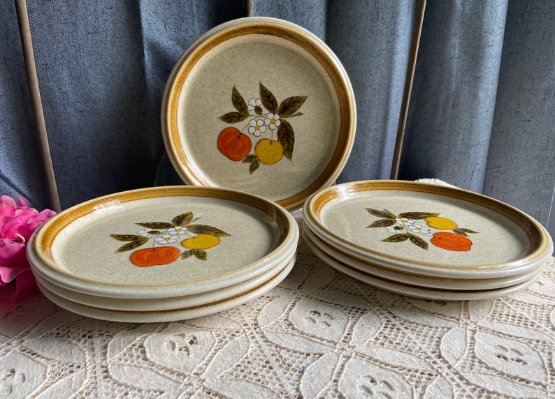 Pode incluir: Conjunto de seis pratos de jantar de cer&acirc;mica castanho e bege com um design floral que apresenta fruta laranja e amarela, folhas verdes e flores brancas.