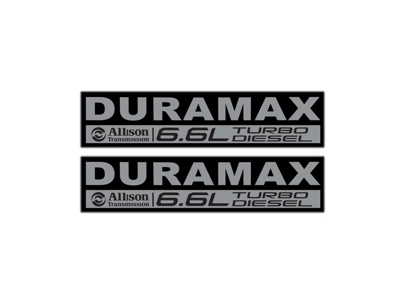 May include: Two black rectangular decals with the word "DURAMAX" in large, gray capital letters. Below, the text "Allison Transmission" and "6.6L TURBO DIESEL" are also displayed in gray.