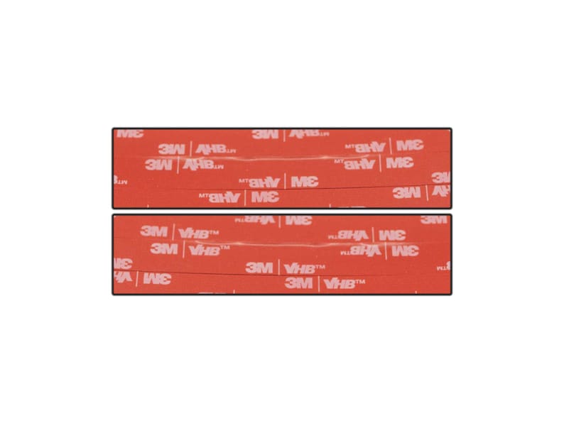 May include: Two rectangular adhesive strips with red backing. The text "3M VHB" and "3M" are printed in white on the red surface. The strips are designed for bonding and mounting applications.
