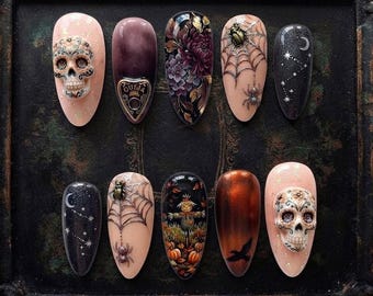 Puede incluir: Un juego de diez uñas postizas en forma de almendra con diseños de Halloween, que incluyen calaveras en 3D, una planchette de Ouija, patrones florales oscuros, telarañas con arañas, constelaciones, un espantapájaros y un cuervo negro.