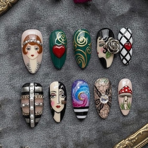 May include: A collection of ten artificial nails with various designs. The designs include faces, hearts, swirls, and a mushroom. Colors include red, green, gold, black, white, and blue. Some nails feature embellishments like pearls and a silver rose.