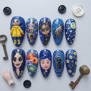 May include: A set of ten blue almond-shaped press-on nails featuring detailed hand-painted characters and motifs including a doll in a yellow raincoat, a clown, a boy with goggles, a cannon, a moon, a woman with button eyes, tickets, and keys.