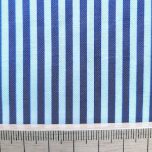 May include: Blue and white striped fabric with a wooden ruler at the bottom.