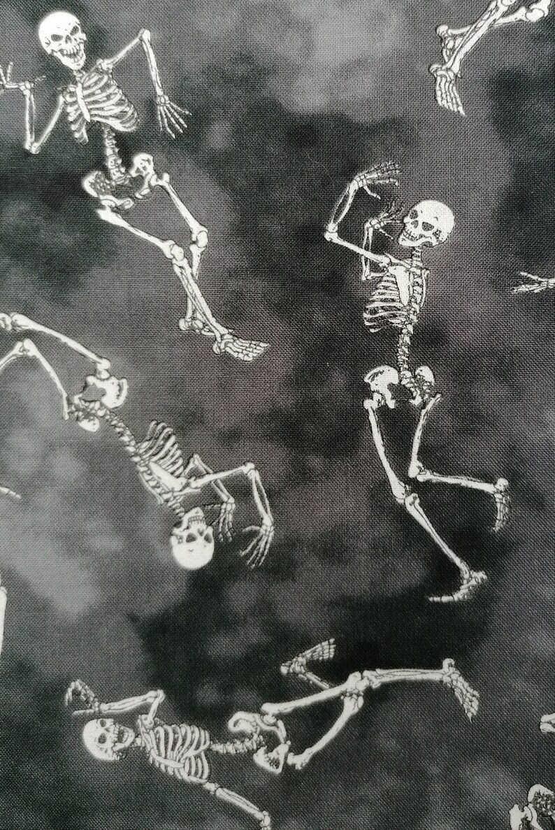 May include: Black and white fabric with a repeating pattern of skeletons. The skeletons are in various poses, some are dancing, some are standing, and some are lying down.