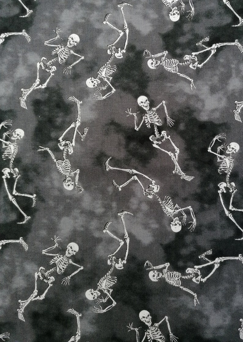 May include: A black and white fabric with a repeating pattern of skeletons dancing. The skeletons are white and the background is a dark grey with a mottled, tie-dye effect.