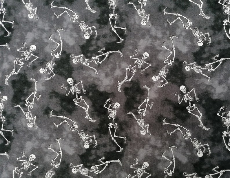 May include: A black and white fabric with a repeating pattern of skeletons dancing. The skeletons are white and the background is a dark grey with a mottled, tie-dye effect.