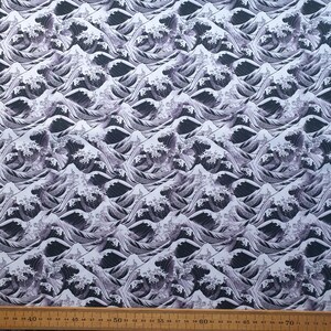 May include: A fabric featuring a repeating pattern of stylized ocean waves in grey and white. The design shows cresting waves with foamy tops, creating a dynamic and textured appearance. Suitable for various craft projects. Measurements are in centimetres.