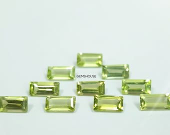 Puede incluir: Una colección de diez gemas rectangulares de color verde claro. Las gemas están dispuestas sobre una superficie blanca. El texto "GEMSHOUSE" es visible en la esquina superior derecha.
