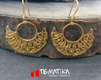 May include: A pair of gold-toned earrings with a crescent moon design and a circle in the center. The earrings are made of metal and have a delicate, intricate design.