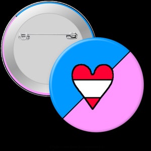 May include: A round button pin with a blue and pink background, and a red and white heart design. The pin has a safety pin on the back and a silver metal rim. The design is simple and colorful.