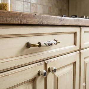 Pomelli e maniglie per cassetti in porcellana con decorazioni floreali, ferramenta in ottone anticato in stile rustico.
