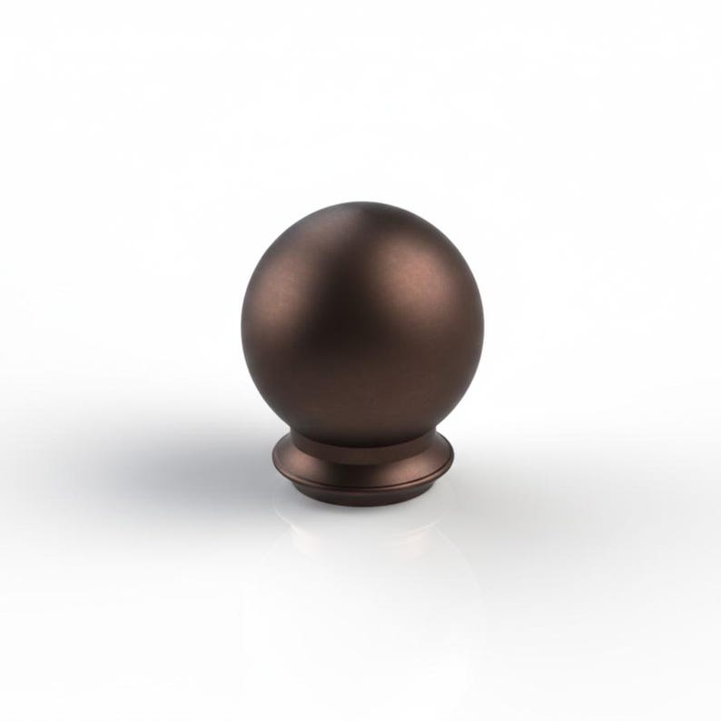 May include: A bronze-coloured, spherical finial with a decorative base. The finial has a smooth, matte finish and is designed for decorative purposes. The base features a stepped design, adding visual interest to the overall form.