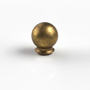 May include: A bronze-coloured, spherical furniture knob with a textured surface. The knob sits on a short, rounded base. The design is simple and classic, suitable for various furniture styles.